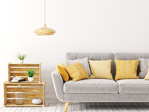 white_wall_lounge_room_grey_couch_timber_crate_table_yellow_cushions_yellow_lamp